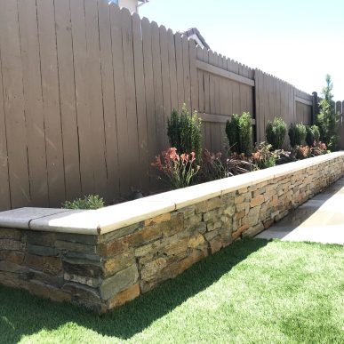 Professional backyard landscaping design with artificial turf and decorative garden beds