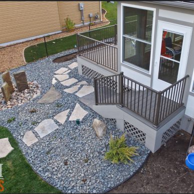 Decorative rock bed installation beside brick home in Saint Charles MO