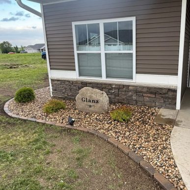 Landscape design stone installation along house foundation in Saint Charles