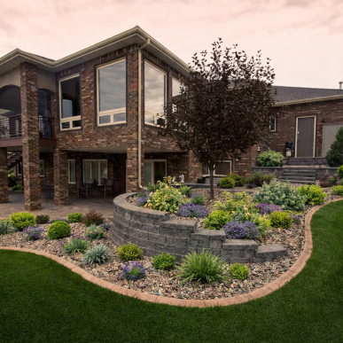 Front yard landscape design with Japanese maple tree, white river rock, and decorative shrubs at a home in Saint Charles Missouri.